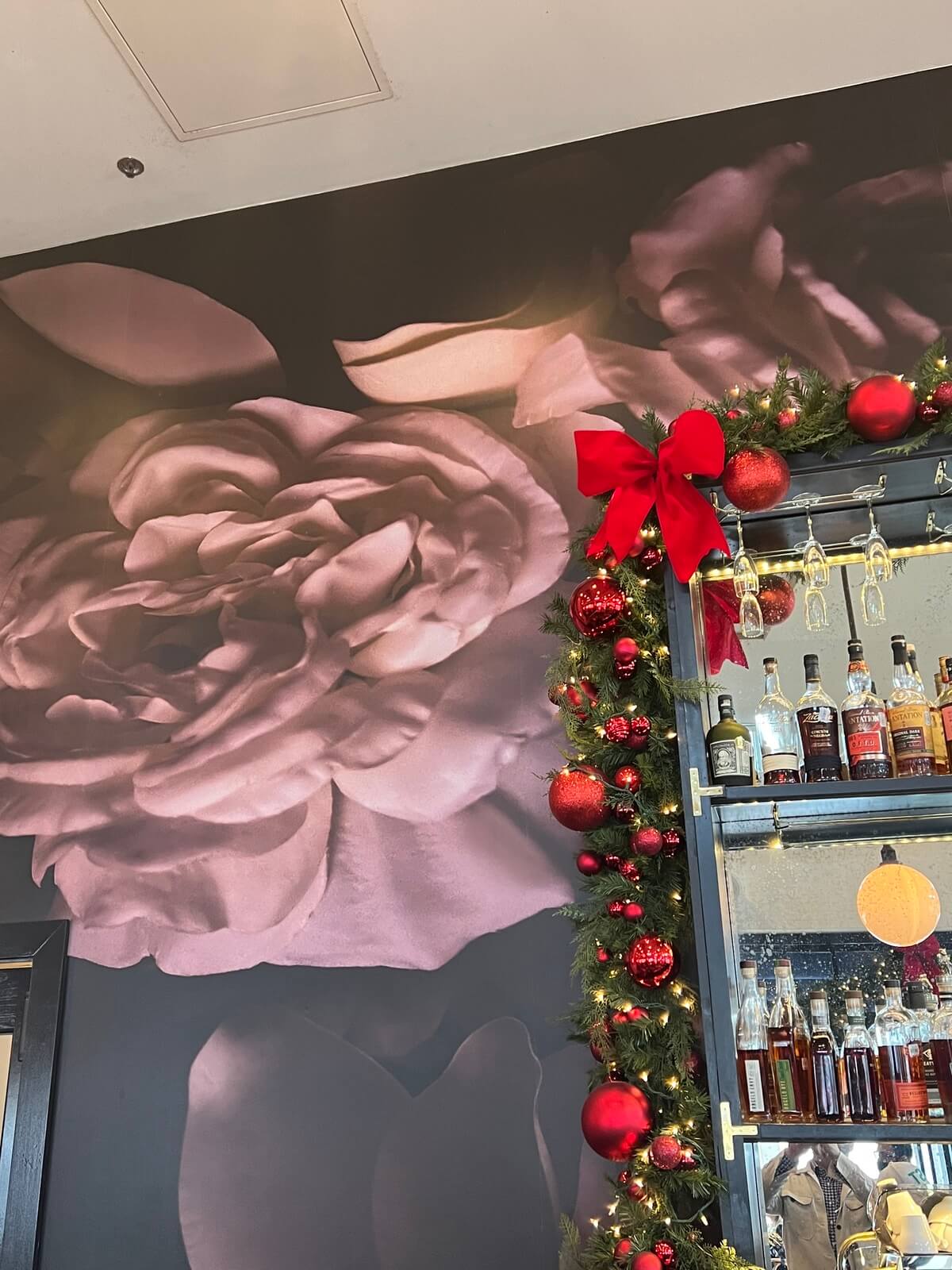 Another view of custom rose Newlon paper installed at restaurant behind bar
